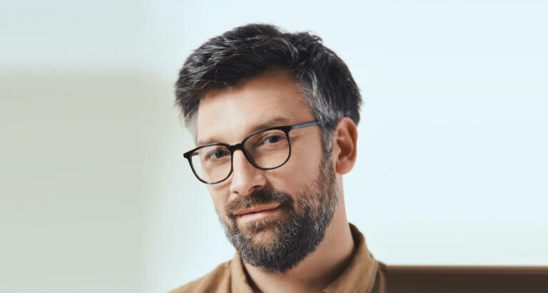 Mann traegt eine dunkelbraune Korrektionsbrille mit eckigen Glaesern