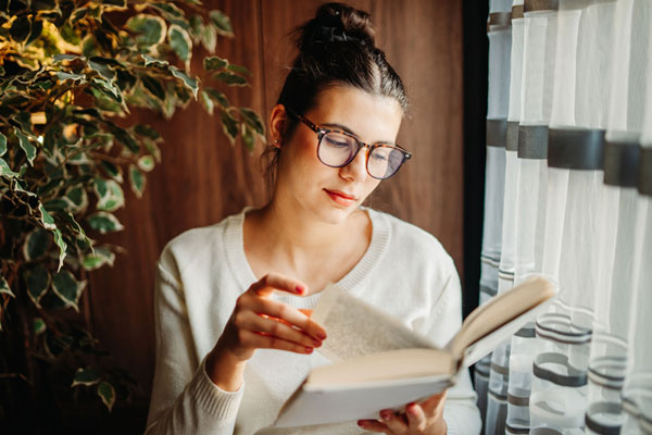 Frau mit Brille liest ein Buch